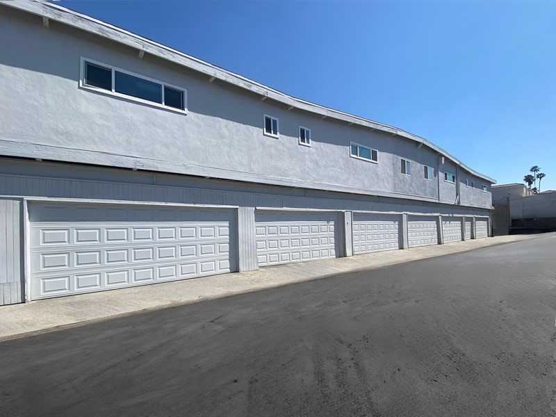 Row of white garage doors along the rear drive at Rock Ridge