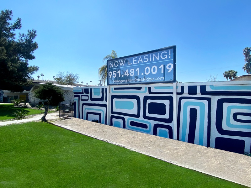 Street-facing wall at Rock Ridge painted with a navy and light-blue geometric mural, with a lawn in front