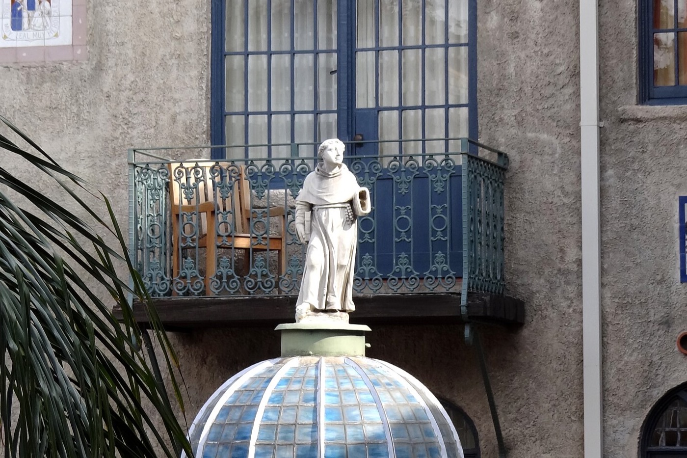 Courtyard of the Mission Inn in downtown Riverside, with a tiled dome, a statue and wrought-iron balconies